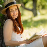 romantic-young-lady-straw-hat-reading-book-sitting-garden_549566-266