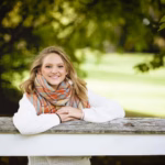 shallow-focus-shot-female-with-her-hands-fence-while-smiling-camera_181624-7163